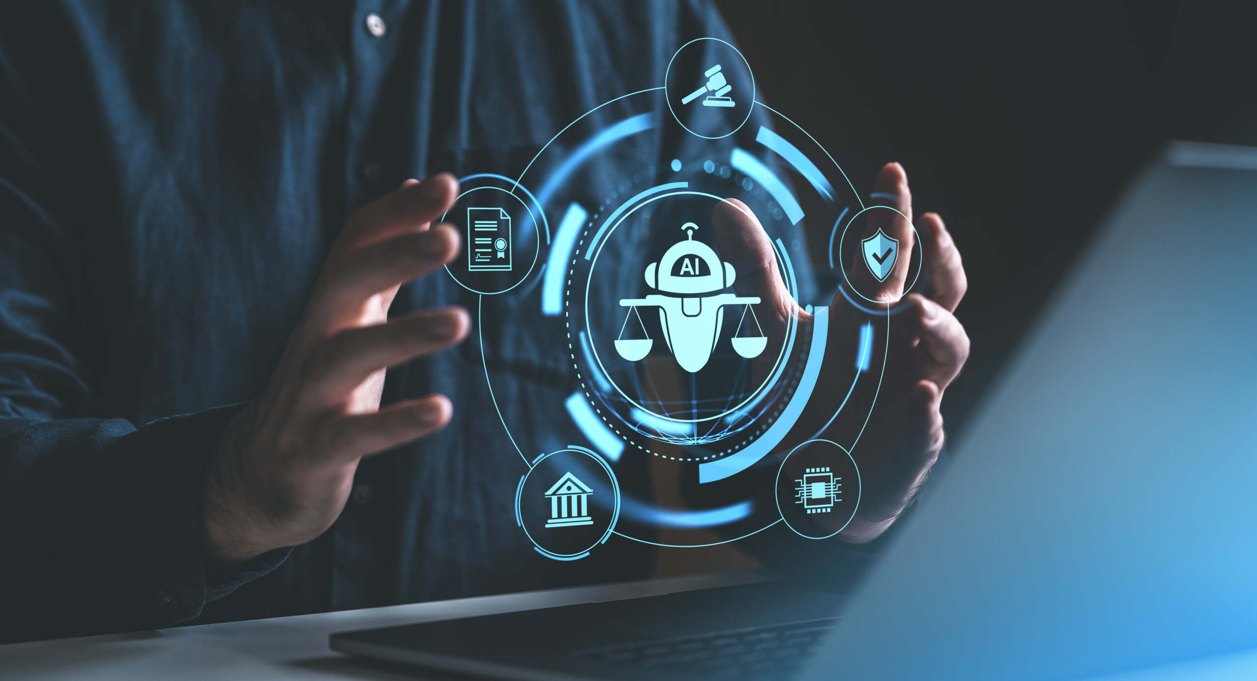 Man hand holding glowing hologram hud with chat bot and scales, laptop on desk. Ai regulation and compliance. Concept of business policy, virtual machine learning ethical code